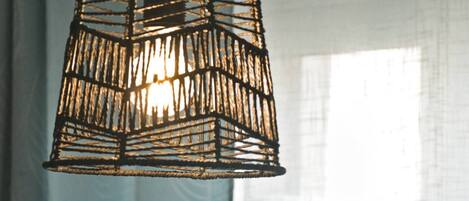 A hanging light fixture with a woven design.