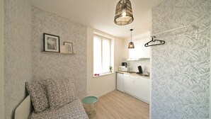 Ein kompakter Wohnraum mit Bett, Küchenzeile und Essecke.