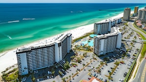 A beachfront hotel with multiple high-rise buildings, a parking lot, and a clear view of the ocean. - Remodeled! Beachfront Wraparound Balcony Edgewater (Panama City Beach)