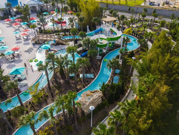 A water park with multiple pools, slides, and a covered area with umbrellas.