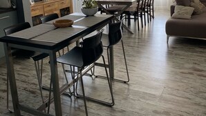 Moderni olohuone, jossa on myös ruokailutila. Huoneeseen kuuluu sohva, ruokapöytä ja tuolit.
