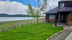 A well-maintained lawn with a wooden fence and a gravel path leading to a wooden building with a metal roof. - On Lake Hatcher! Great Views, Quiet Area, Close to Uptown, New Hot Tub! (Pagosa Springs)