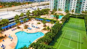 Hotel med swimmingpool, tennisbaner og parkeringsplads.