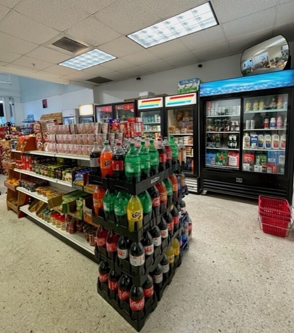Un pasillo de un supermercado con estantes llenos de diversas bebidas y aperitivos.