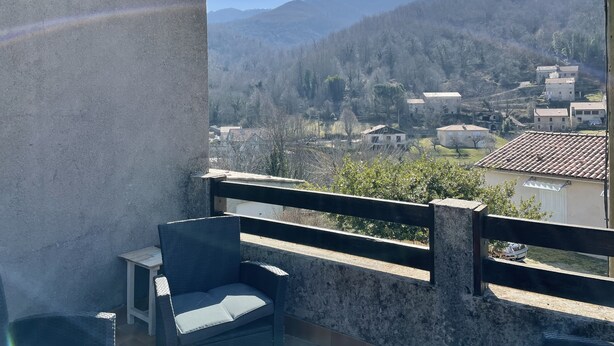 Ein Balkon mit Blick auf ein Dorf und Berge.