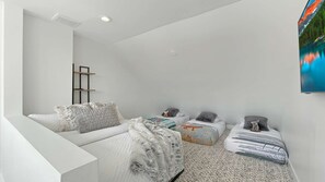 A modern bedroom with a white sofa, a small bed, a TV, and a bookshelf. - Upscale Abode w/Mountain & Golf Course Views•Sleeps 11•BBQ•Steps to Free Shuttle (Park City)