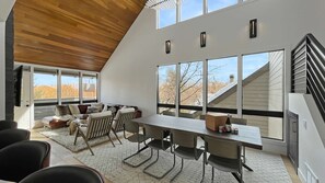 A modern interior with a dining area, large windows, and a staircase. - Upscale Abode w/Mountain & Golf Course Views•Sleeps 11•BBQ•Steps to Free Shuttle (Park City)