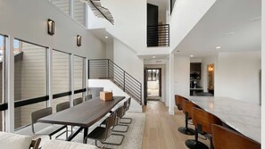 A modern interior with a dining area, kitchen, and staircase. - Upscale Abode w/Mountain & Golf Course Views•Sleeps 11•BBQ•Steps to Free Shuttle (Park City)