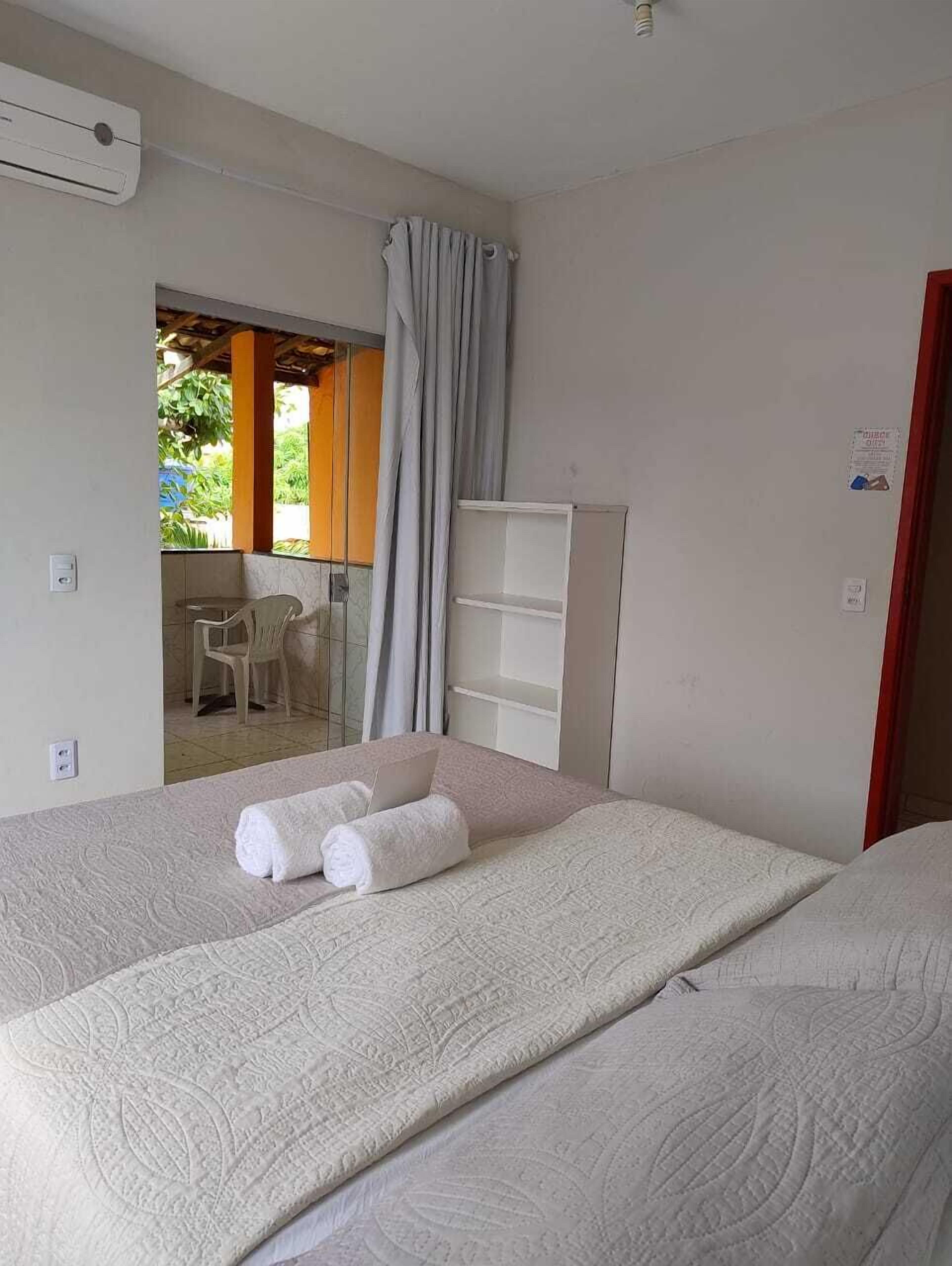Una habitación de hotel con cama, escritorio y ventana con cortinas.