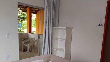 Una habitación de hotel con cama, escritorio y ventana con cortinas.