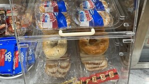 A bakery display case with various types of pastries and packaged doughnuts.