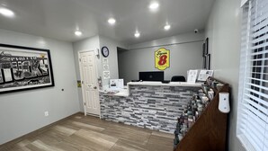A reception area with a white counter, a clock, and a sign reading "Super 8 by Wyndham".