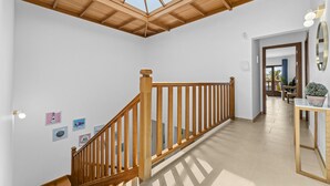 A spacious room with a wooden staircase, a skylight, and a view of the outdoors. - Villa Rosa (Playa Blanca)