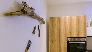 A kitchen with a wooden cabinet and a hanging wooden branch. - LA NASSA SUITES MAZARA (Mazara del Vallo)