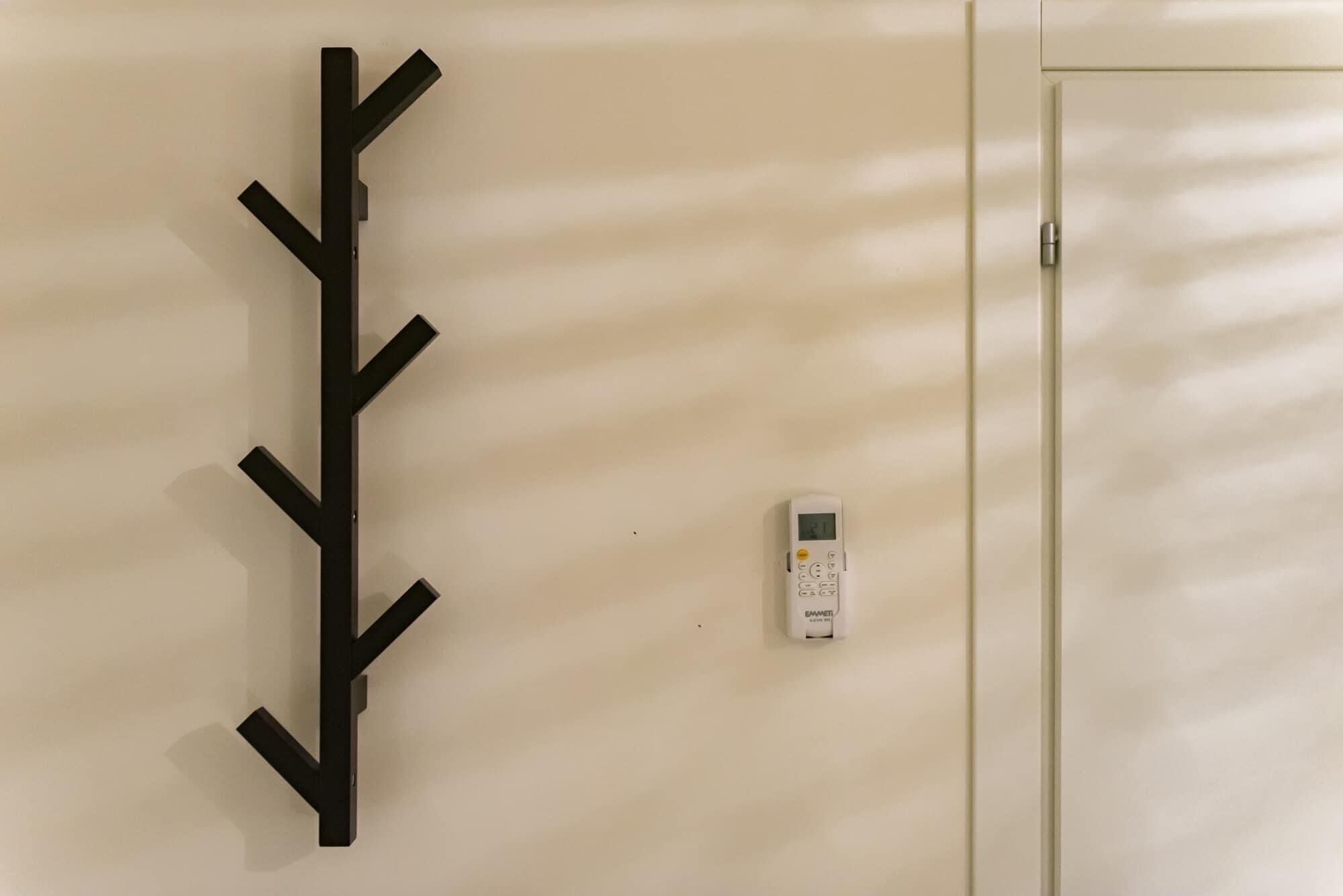 Un panel de control de seguridad montado en la pared y una obra de arte abstracta negra.