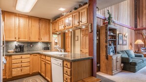 Una cocina con armarios de madera, lavavajillas y encimera con lavabo.