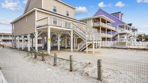 A beachfront property with multiple levels, including a covered area with a staircase leading to the upper floors. - Pet Friendly Ocean Front Home - Shore Delight (North Myrtle Beach)