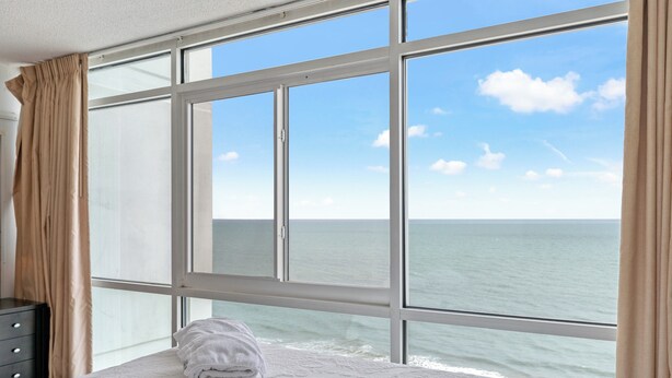 A hotel room with a large window offering a view of the ocean. - Regency Towers 1602 -Pool & Hot Tub Year-Round (Myrtle Beach)