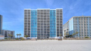 A high-rise hotel with multiple balconies, located adjacent to a beach. - Regency Towers 1602 -Pool & Hot Tub Year-Round (Myrtle Beach)