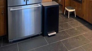 A kitchen with a stainless steel refrigerator, a dishwasher, and wooden cabinetry.