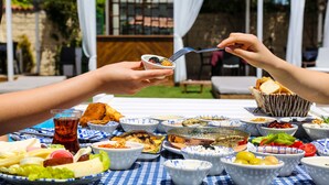 A table set with various dishes and a glass of tea, indicating a meal setting in an outdoor area. - Rikas Alacati (Cesme)
