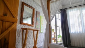 A room with a wooden slat ceiling, a white sofa, a wooden table, and two framed artworks on the wall. - Rikas Alacati (Cesme)