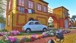 A building made of oranges and lemons, with a vintage car in front.