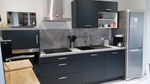 Una cocina moderna con armarios oscuros, electrodomésticos de acero inoxidable y un horno empotrado.