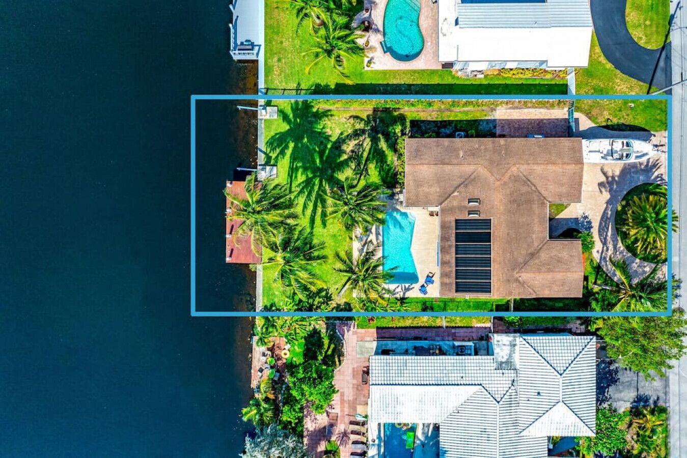 Ett flygbildsfoto av en bostadsfastighet med en swimmingpool, ett stort hus och ett garage.