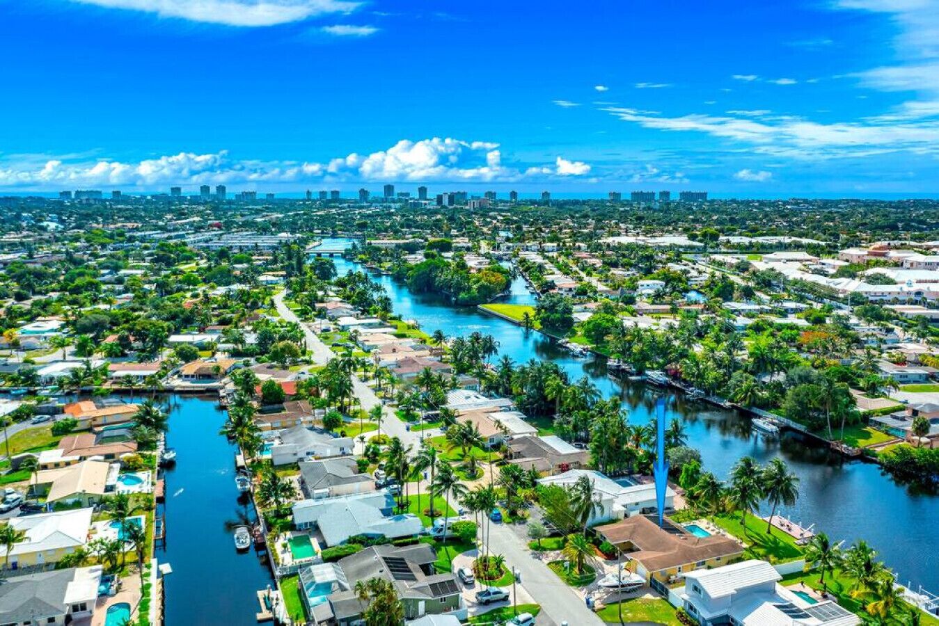 A residential area with houses, a river, and a distant city skyline.