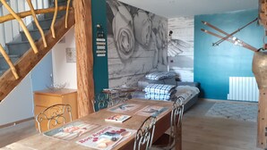 Ein Essbereich mit einem Holztisch, Stühlen und einer Wand mit floralem Wandbild.