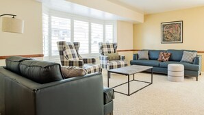 A living room with a sofa, two armchairs, a coffee table, and a window with blinds. - Spacious 3BR Extended Stay: Airport, Downtown, Ski (North Salt Lake)