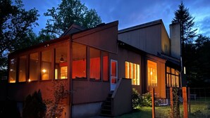 A modern house with large windows and a covered porch. - Modern, Magical Woodsy Escape 1 Hour From NYC (Putnam Valley)