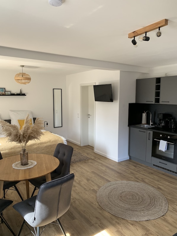 A modern kitchen with grey cabinets, a black countertop, and a built-in oven. - Vacation apartment I Beck-Bräu near Bamberg (Lisberg)