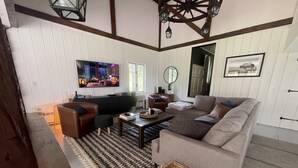 A living room with a sofa, a coffee table, a TV, and a fireplace. - Modern Rustic 5 Bedroom Home In the Foothills of the Catskills Mountains. 5 ⭐️ (Otego)