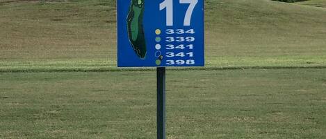 En skylt vid ett golfhål som visar hålnummer 17 och avståndet till greenen.