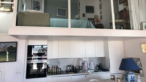 Un appartement à deux niveaux, avec une cuisine au rez-de-chaussée et une chambre à l’étage.