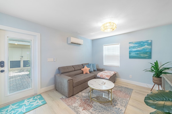 Open space and bright living room with TV and pull out bed.