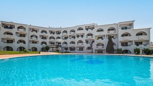Piscina com um edifício ao fundo.