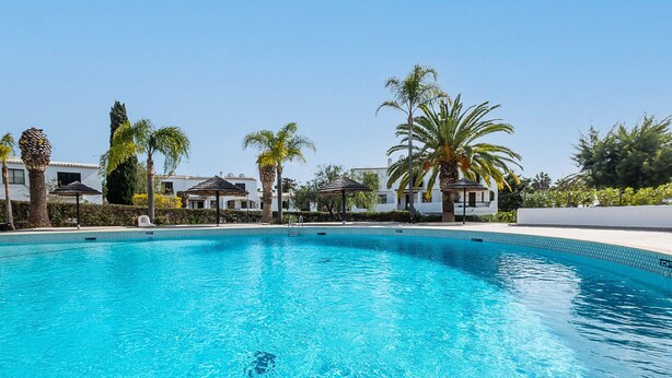 A clear blue swimming pool surrounded by palm trees and white buildings. - #082 Families Only - São Rafael by Home Holidays (Albufeira)