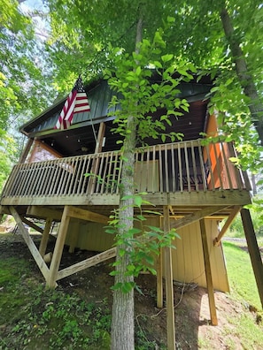A wooden cabin with a balcony and an American flag. - Butterfly Ridge at Avenwood Cabins (New Straitsville)