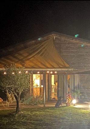 Guests can enjoy a cozy porch with a sloped roof and a chimney, perfect for relaxing with a view.
