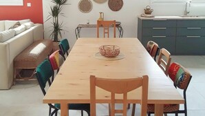 En matplats med ett träbord, stolar och en hängande lampa.