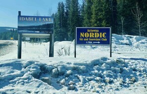 Signs for Idabel Lake Private Lakeside Cottages and Kelowna Nordic Ski and Snowshoe Club.