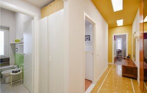 A hallway with a yellow floor, white walls, and a white door leading to a bathroom. - 2 bedroom gorgeous apartment in Rapallo (Rapallo)
