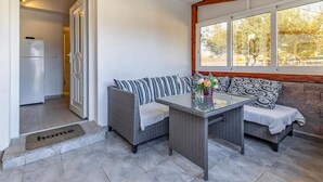A modern kitchen with a built-in refrigerator and a dining area with wicker furniture and a glass table. - Luxurious home in Pomer (Pomer)