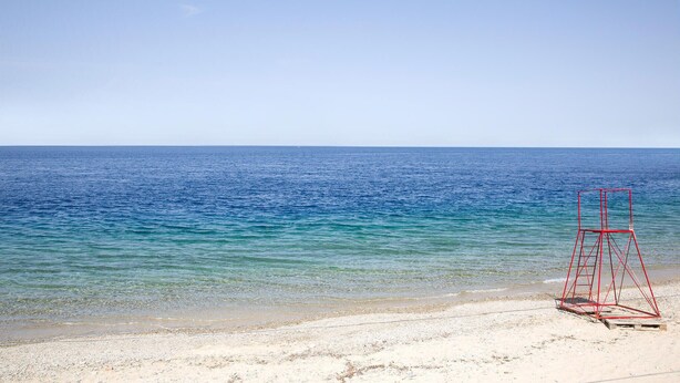 A beach with clear blue water and a red lifeguard chair on the sand. - Pet friendly apartment in Carovigno (Carovigno)