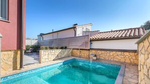 Una piscina con paredes de piedra y techo de azulejos.
