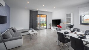 A modern living room with a sofa, a dining table set for two, and a TV. - Pet friendly home in Novigrad (Novigrad)