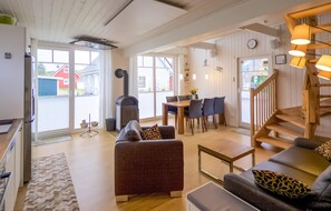 Relax in this stylish living area with a sofa, dining table, and wood-burning stove.
